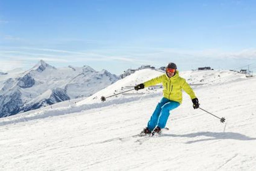 A skier races down the slope during his adult ski lessons for adults for beginners with the Edelweiss Alpine Ski School.