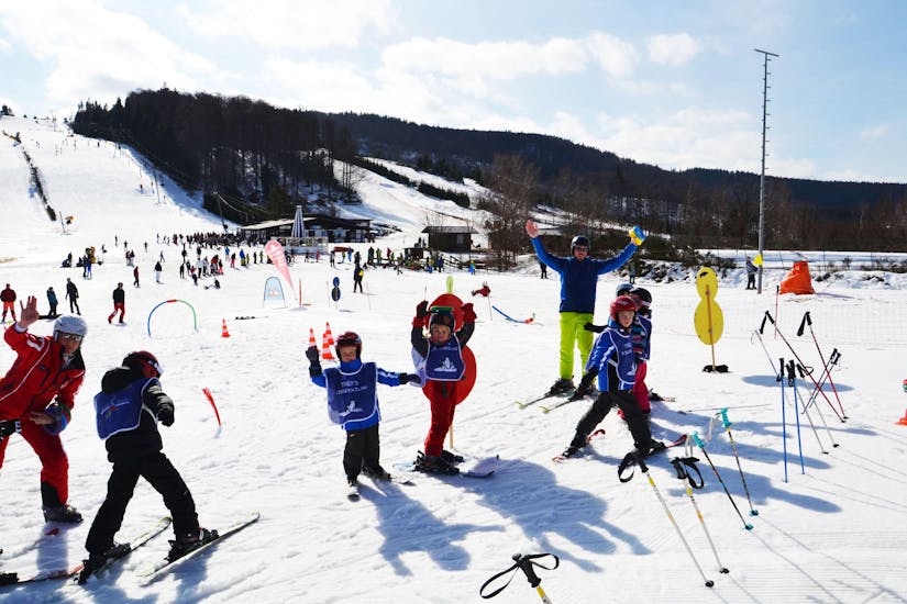 Een groep kinderen is een en al glimlach tijdens de Kids Skilessen (vanaf 5 jaar) voor alle niveaus bij de Skischule Sahnehang.