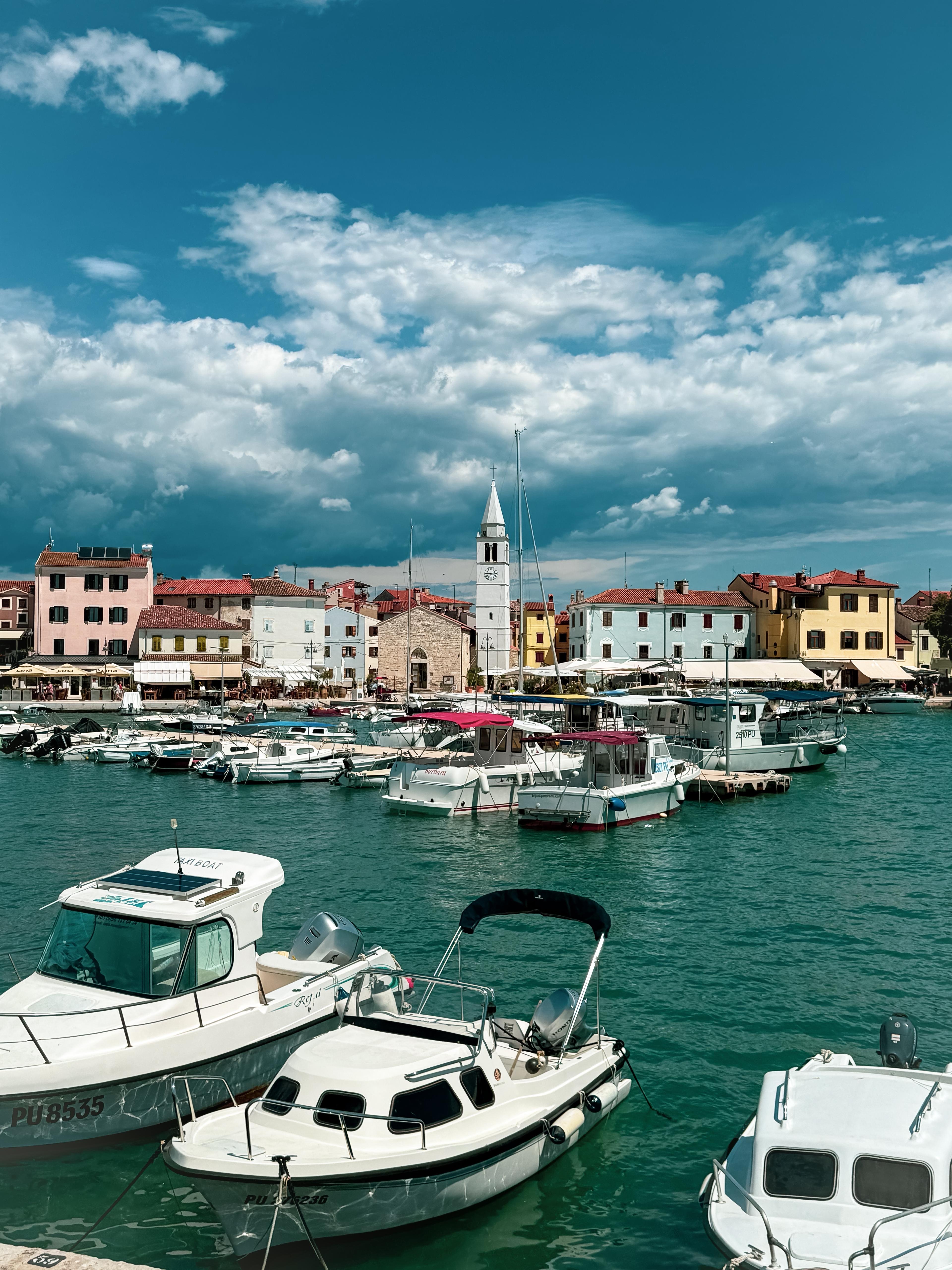 De levendige haven van Pula is gevuld met boten die aangemeerd liggen voor kleurrijke gebouwen, voorafgaand aan een boottocht rond het Brijuni Nationaal Park in Pula inclusief lunch, georganiseerd door Pula Boat Tours-Adventures.