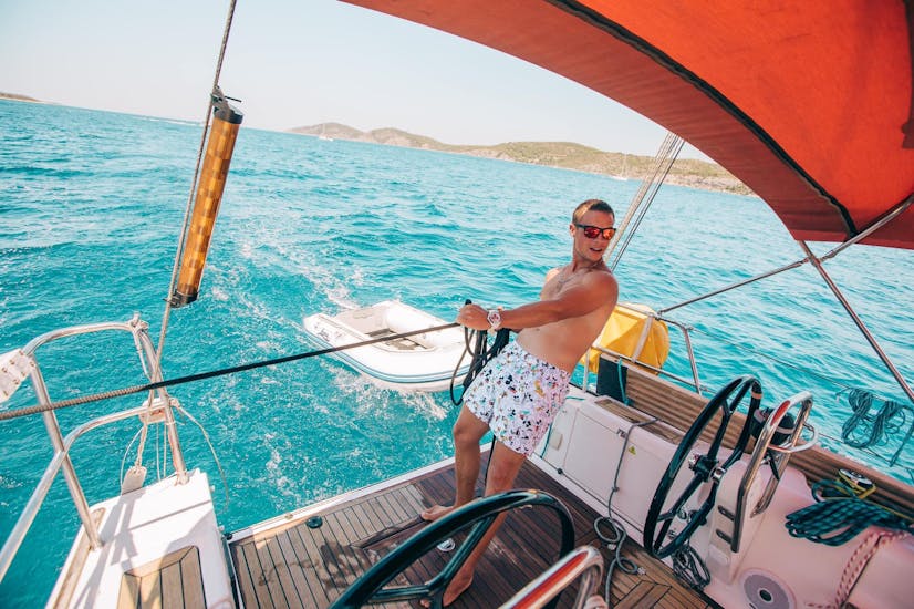 Uomo che naviga a bordo dello yacht durante la gita in barca a vela di un' intera giornata da Hvar alle isole Pakleni Il giorno di navigazione.