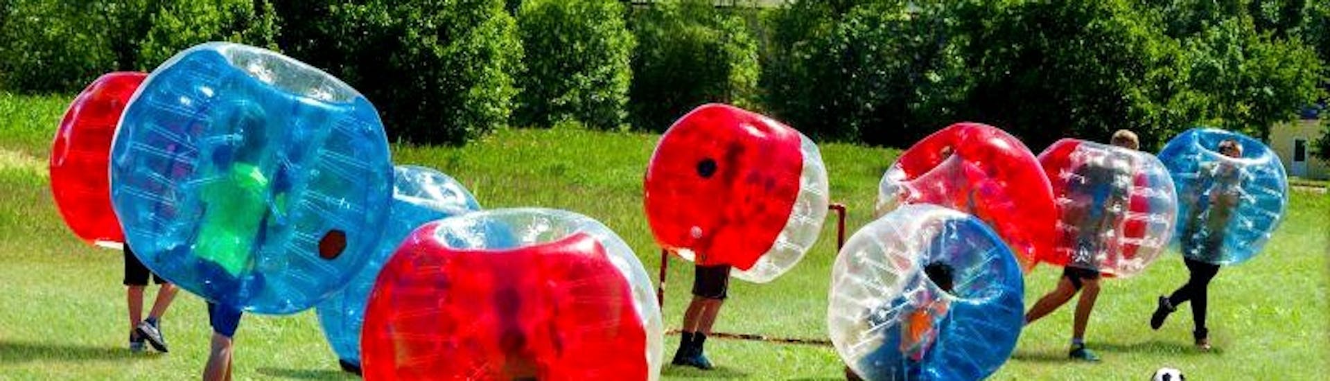 Groep speelt bubble voetbal tijdens het vrijgezellenfeest arrow tag + bubble voetbal gehost door Outdoor Center Baumgarten.