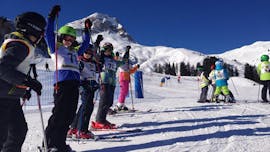 Eine Gruppe von Kindern jubelt beim Kinder-Skikurs für Anfänger mit der Skischule Warth in Warth-Schröcken.