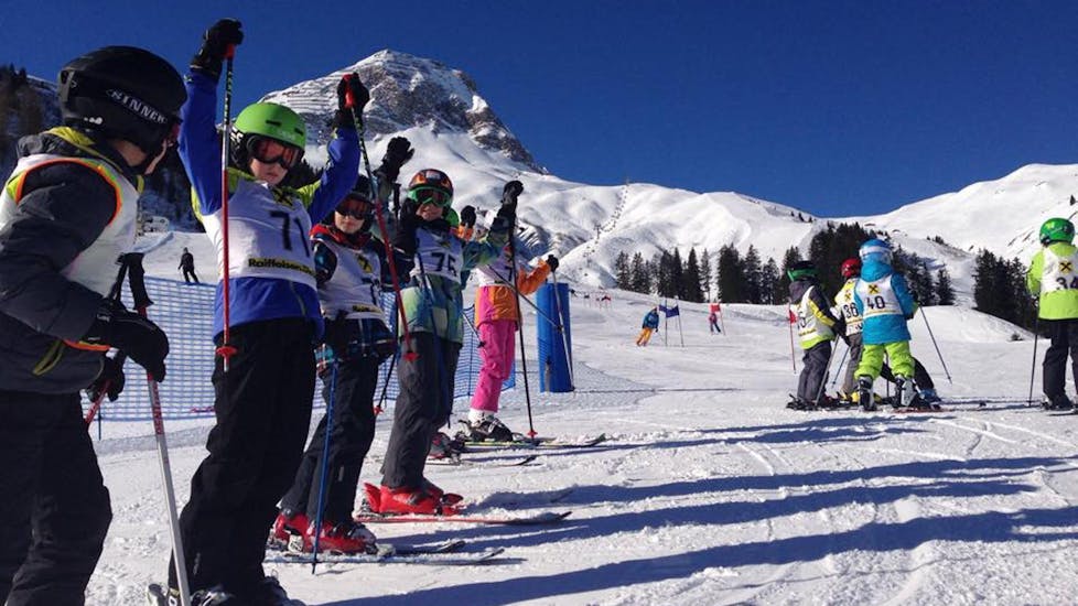 Een groep kinderen juicht tijdens de kinderskiles voor beginners bij skischool Warth in Warth-Schröcken.