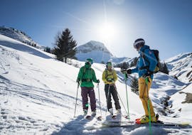 Drie skiërs staan tijdens hun volwassen skilessen voor beginners bij skischool Warth.