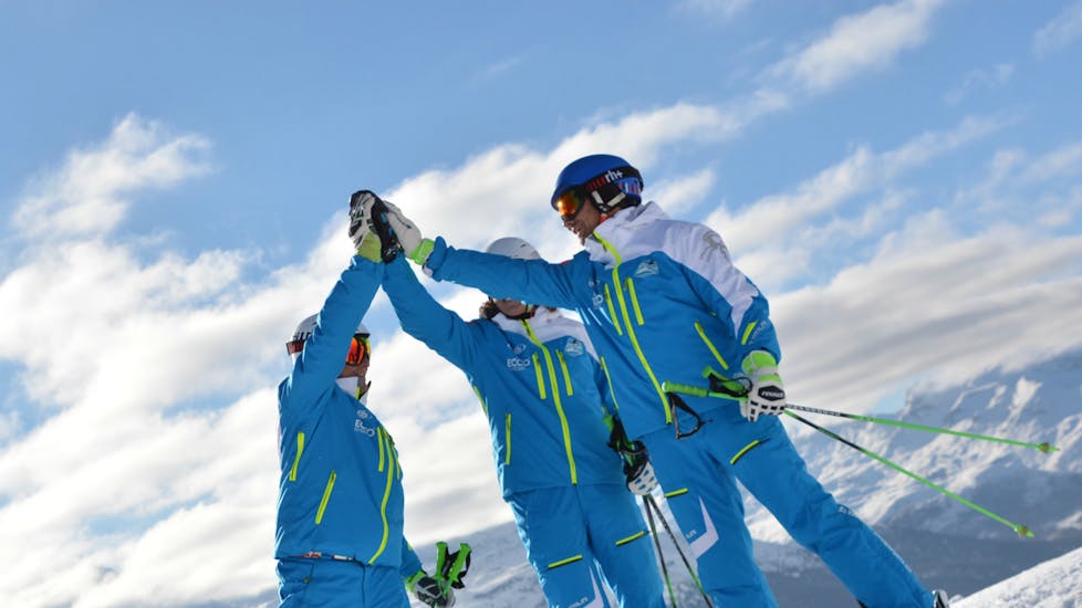 Trois moniteurs de ski de l'école de ski Silvaplana Top Snowsports se félicitent pendant les cours de ski pour Enfants pour les skieurs Expérimentés.