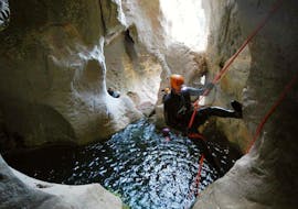 Uomo che si cala nel canyoning sotterraneo di Grotta Donini per esperti con 25Miglia.