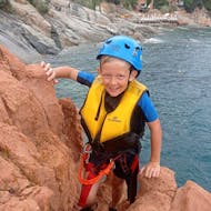 bambino che si arrampica sugli scogli durante il coasteering a Cala E' Luas con 25Miglia.