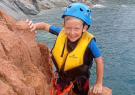Kid on rocks during Coasteering at Cala E' Luas with zip line with 25Miglia Sardinia.