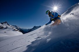 Ein Freerider beim Abfahren eines Berges während seines Off-Piste-Skikurses "Crashkurs" für alle Könnerstufen mit der Skischule Warth in Warth Schröcken.