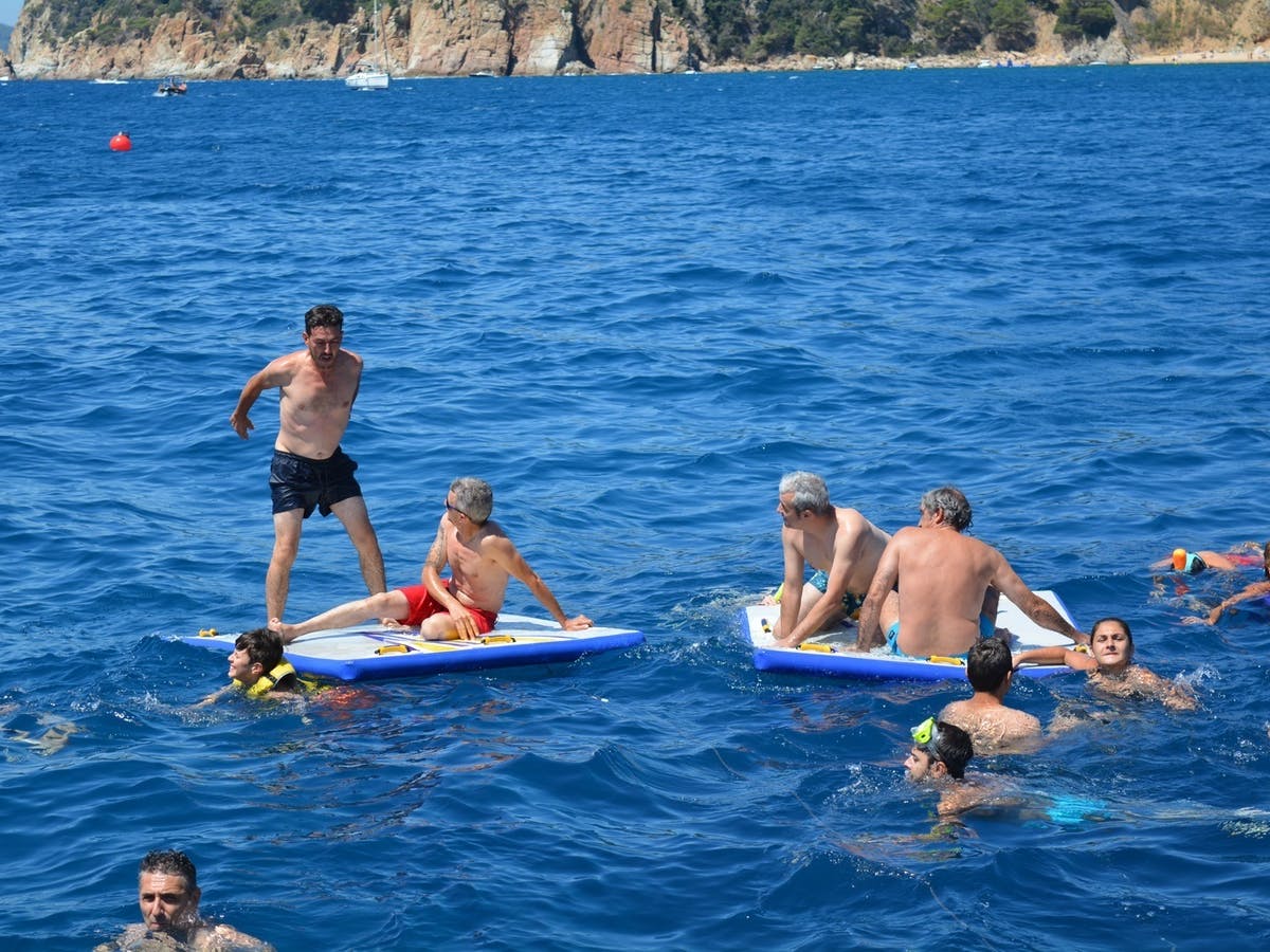 People swimming and having fun in the water with Catamaran Sensations.
