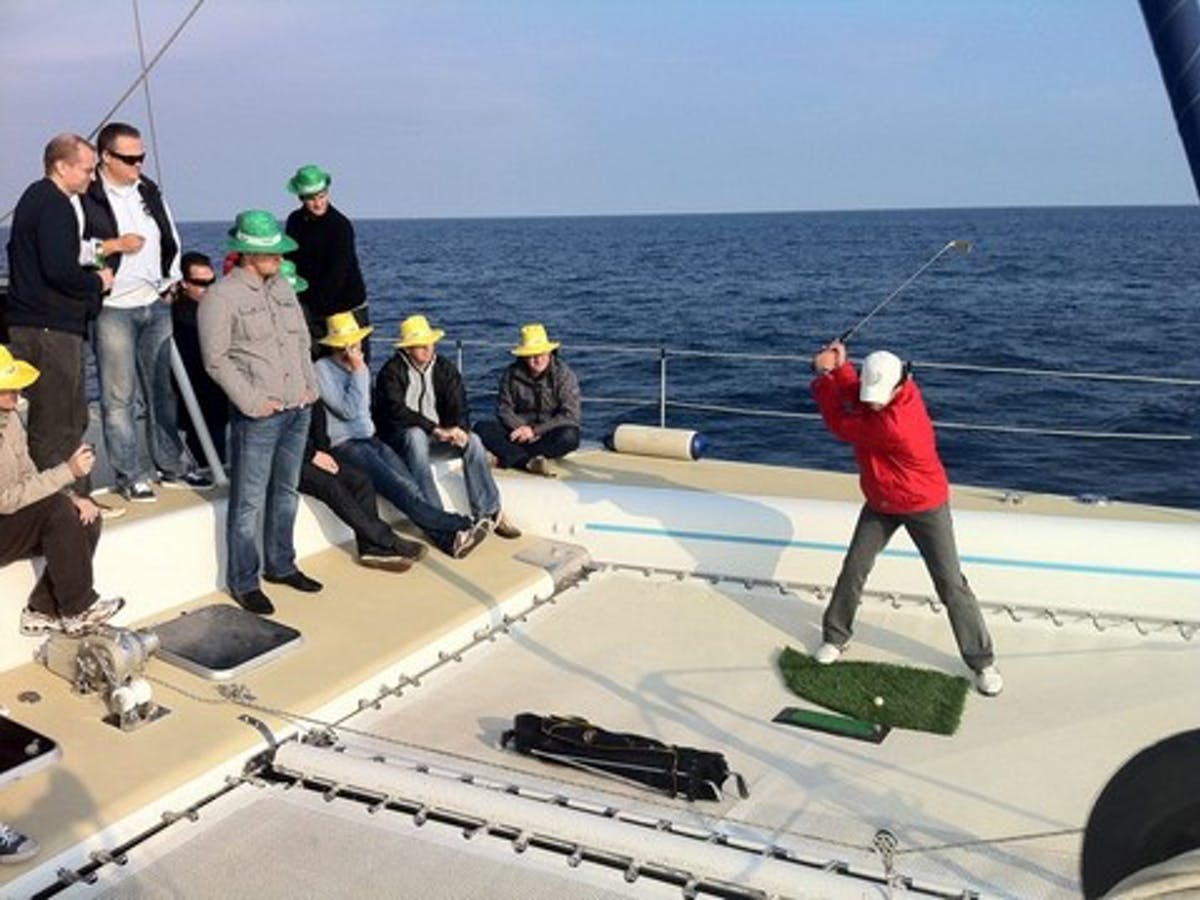 People playing golf aboard Catamaran Sensations.