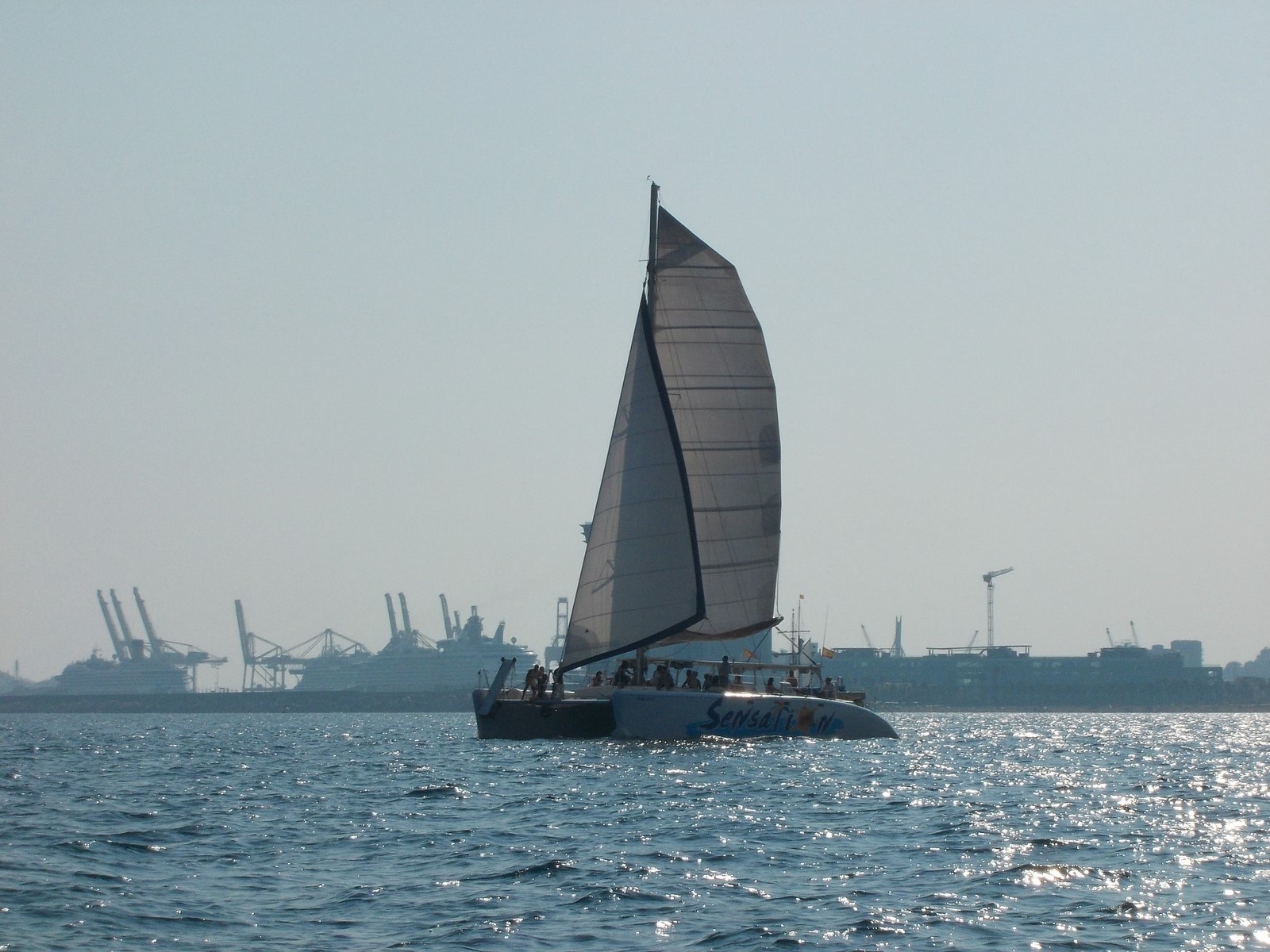 A boat from Catamaran Sensations sailing around Barcelona's coast.