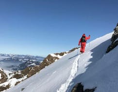 A skier going up the mountain during Private Ski Touring Guide for All Levels with S4 Snowsport Fieberbrunn.