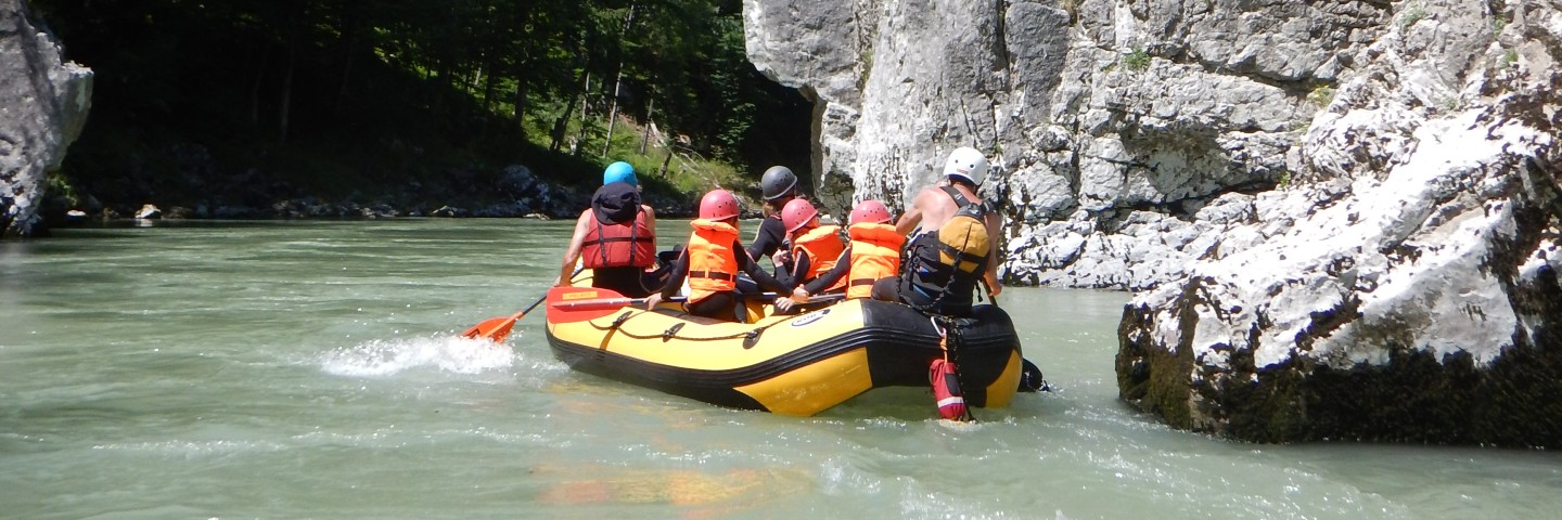 Ein Boot voller Menschen beim Rafting auf der Kitzbüheler Ache für Familien mit Outdoor Guide Kaiserwinkl.