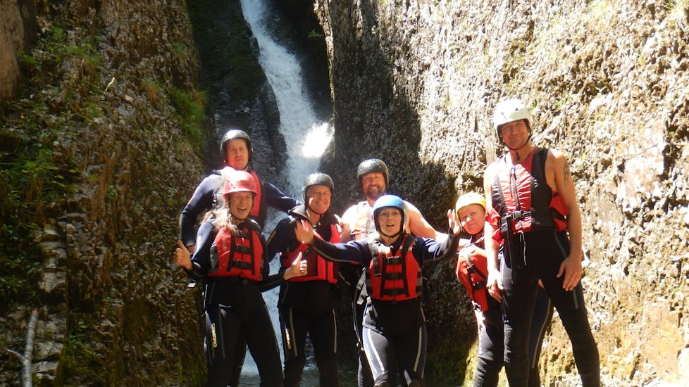 A group of friends smiling into the camera at the end of their Rafting & Canyoning Tour Kitzbüheler Ache with Outdoor Guide Kaiserwinkl.