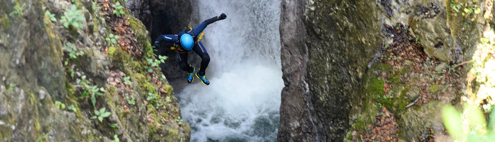 A customer jumping into the canyon at Canyoning Jumps and Action Strubklamm with Outdoor Guide Kaiserwinkl.