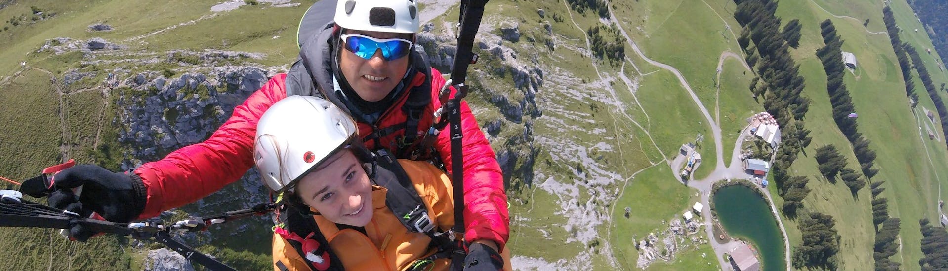 Ein Kunde und sein Pilot lächeln in die Kamera beim Tandem-Paragliding vom Brunni in Engelberg-Explore.