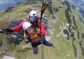 A customer and his pilot from smiling into the camera during Tandem Paragliding from Brunni in Engelberg-Explore with Paragliding Flybypara..