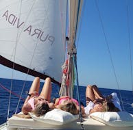 3 junge Mädchen sonnen sich auf dem Boot während der privaten ganztägigen Bootsfahrt auf Mallorca ab Port d'Andratx mit Pura Vida Sailing Mallorca.