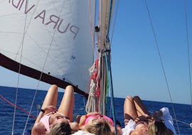 3 chicas jóvenes toman el sol en el barco durante la excursión privada en barco de día completo en Mallorca desde Port d'Andratx con Pura Vida Sailing Mallorca.