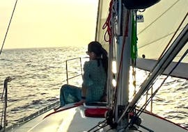 Una joven descansa en cubierta durante la excursión en barco al atardecer en Mallorca desde Port d'Andratx con Pura Vida Sailing Mallorca.