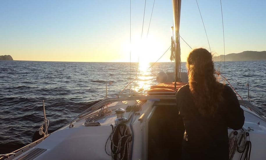Une femme regarde la mer pendant l'excursion en bateau au coucher du soleil à Majorque depuis Port d'Andratx avec Pura Vida Sailing Mallorca.