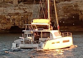 View of the Catamaran in front of the cliffs in Polignano a Mare during the Private catamaran trip to the Polignano a Mare caves with Pugliamare.