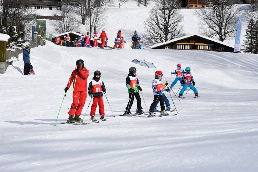 Während des Kinder-Skikurses (3-15 J.) für alle Levels - Männlichen mit der Schweizer Skischule Grindelwald erkundet eine Gruppe von fortgeschrittenen Skifahrern gemeinsam mit dem Skilehrer die Pisten.