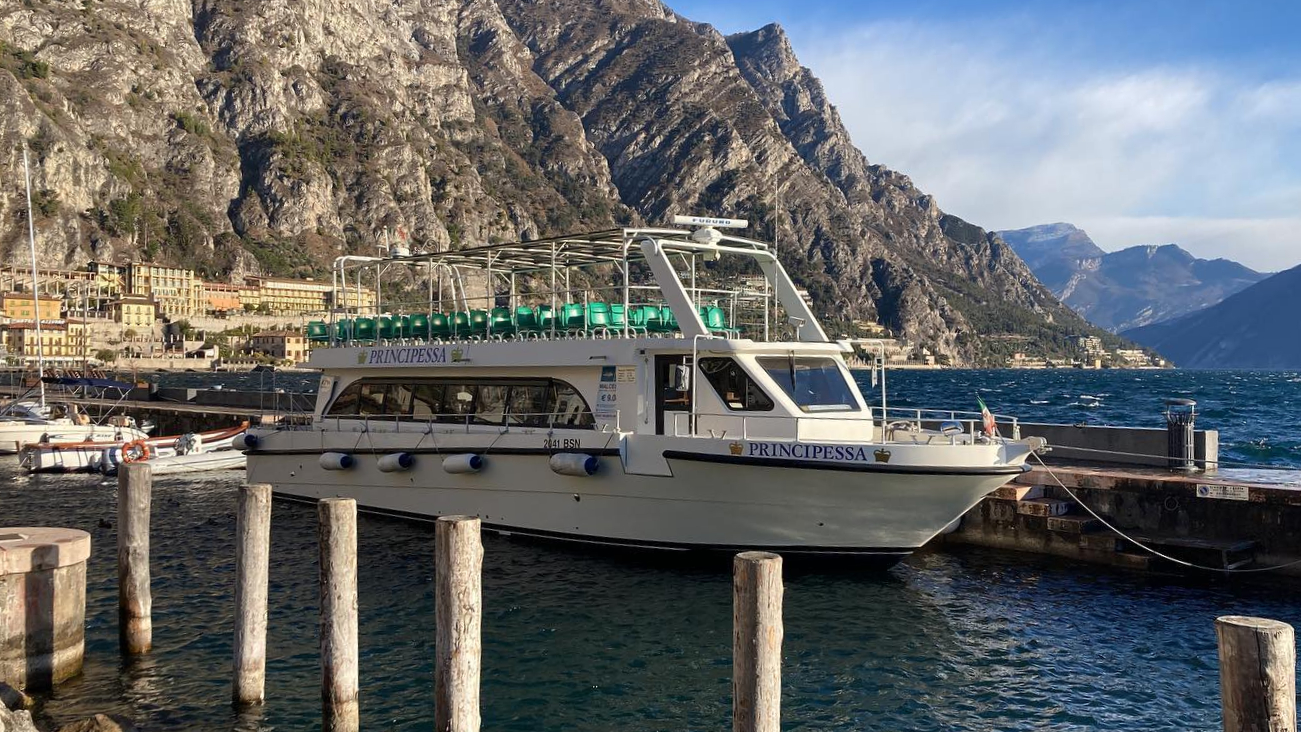View of a boat at a dock in Garda Lake during the Evening ride on Garda Lake to Malcesine - Round Trip with Garda escursioni.