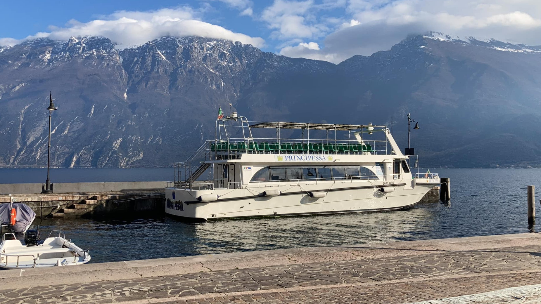 Uitzicht op een boot aan een steiger in het Gardameer tijdens de avondtocht op het Gardameer naar Malcesine - retourtocht met Garda escursioni.