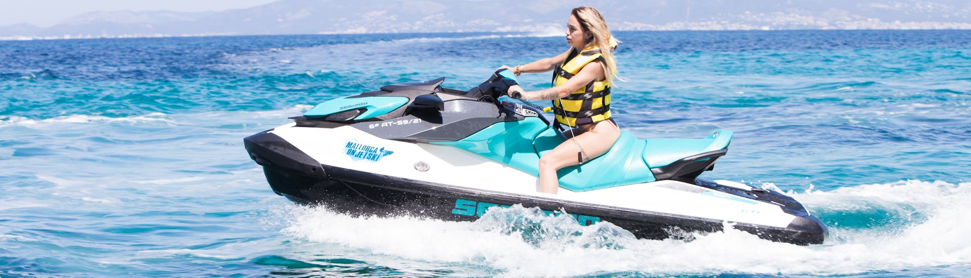 A woman enjoying a ride in the sea during a Jet Ski Safari to Cala del Mago and Portals Vells with Portals on Jetski.