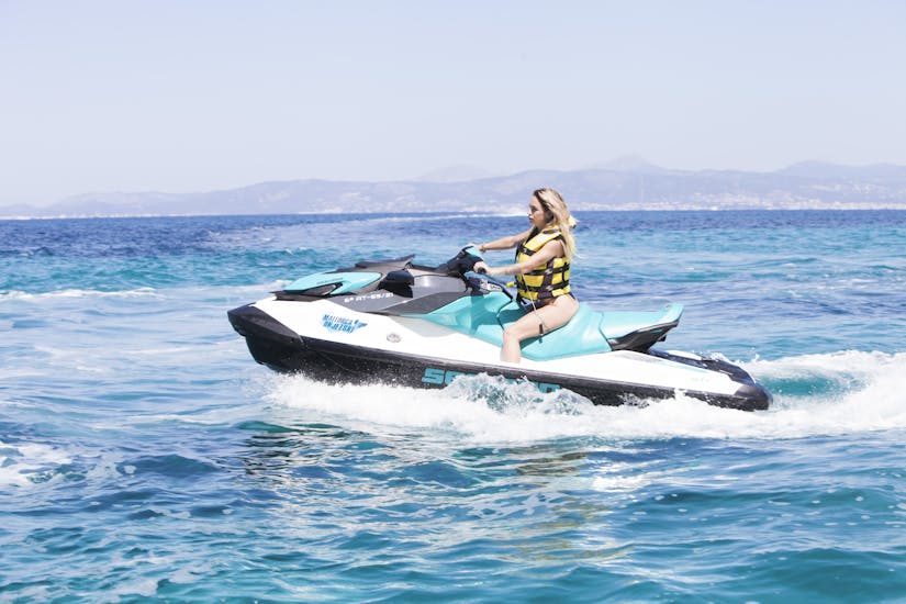 Eine Frau fährt auf einem Jetski während einer Jetski-Safari am Strand von Cala D'or mit Cala D'or On Jetski.