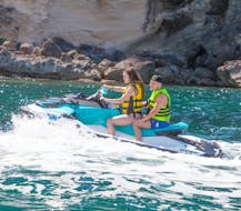 A couple riding a jetski during a Jet Ski Safari with Sunset in Cala D'or with Cala D'or On Jetski.