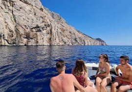 Persone sul gommone che guardano la costa durante Gita in barca a Cala Moresca con snorkeling e avvistamento delifni con BlueSea Charter and Tour Olbia.