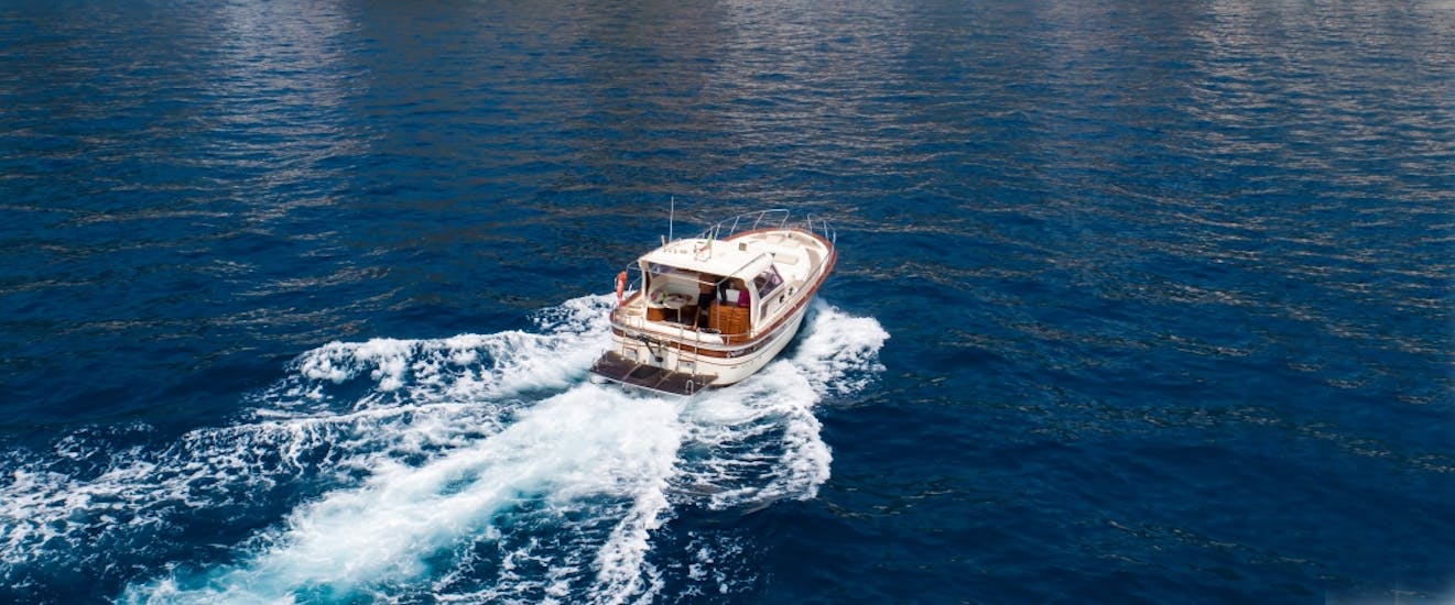 Ein Boot von Capitano Ago Costiera Amalfitana fährt durchs Meer während der Bootstour von Sorrento nach Procida und Ischia.