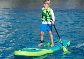 A kid is doing an Inflatable SUP Hire at in Le Lavandou with Transparent’Sea. 