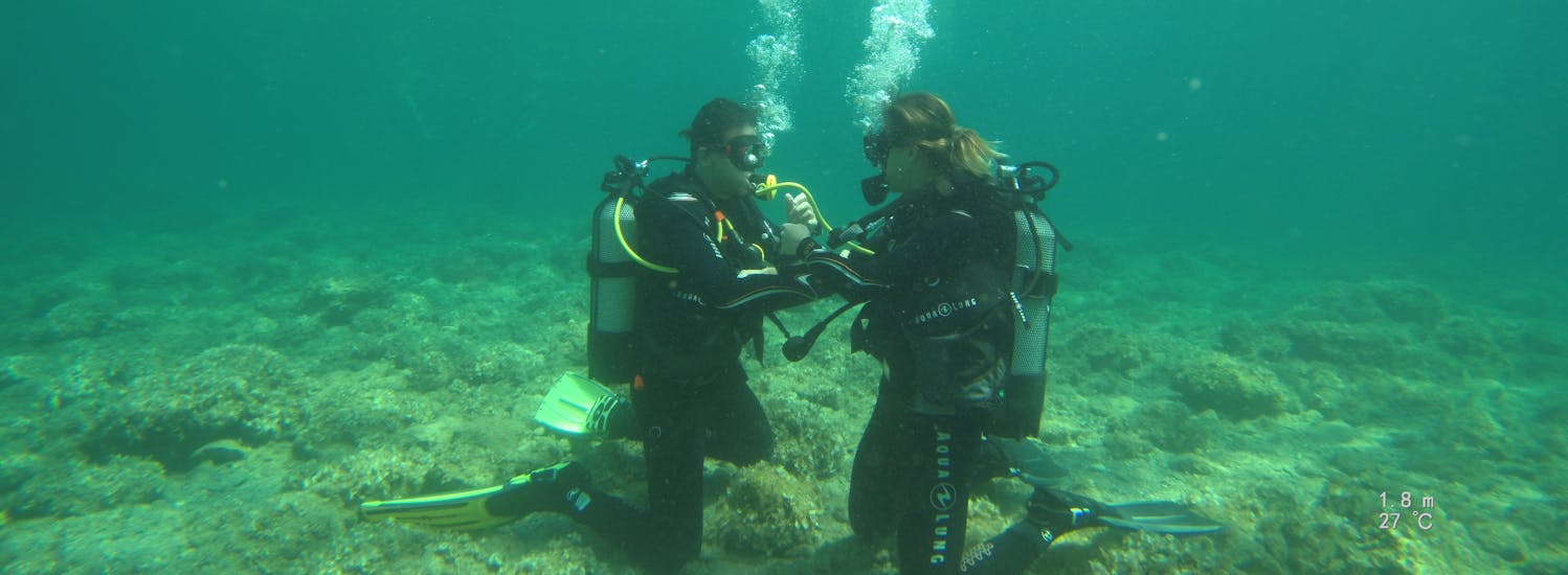 A couple diving during a PADI Open Water Diving Course in Kallithea for Beginners with Rhodes Diving Academy.