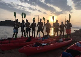 View of a group of people with paddles and kayaks with the sunrise light during the Guided Sunrise Kayak Tour to Proratora Island with cofee & snorkeling with Ecosport Sardinia.
