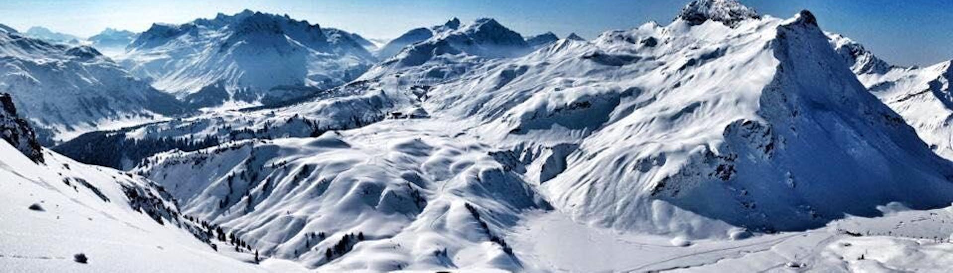Een skiër met uitzicht op een berg tijdens privélessen off-piste skiën voor alle niveaus met skischool Warth Vorarlberg Snowsports.