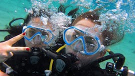 2 Freundinnen haben Spaß unter Wasser beim ihrem ersten Tauchgang während des Schnuppertauchens am Lia Beach in Mykonos mit GoDive Mykonos.