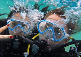 2 amis s'amusent sous l'eau lors de leur première plongée pendant le cours de découverte de la plongée sous-marine à Lia Beach à Mykonos avec GoDive Mykonos.