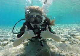Frau unter Wasser während des Open Water Diver Kurs für Anfänger am Lia Beach in Mykonos mit GoDive Mykonos.