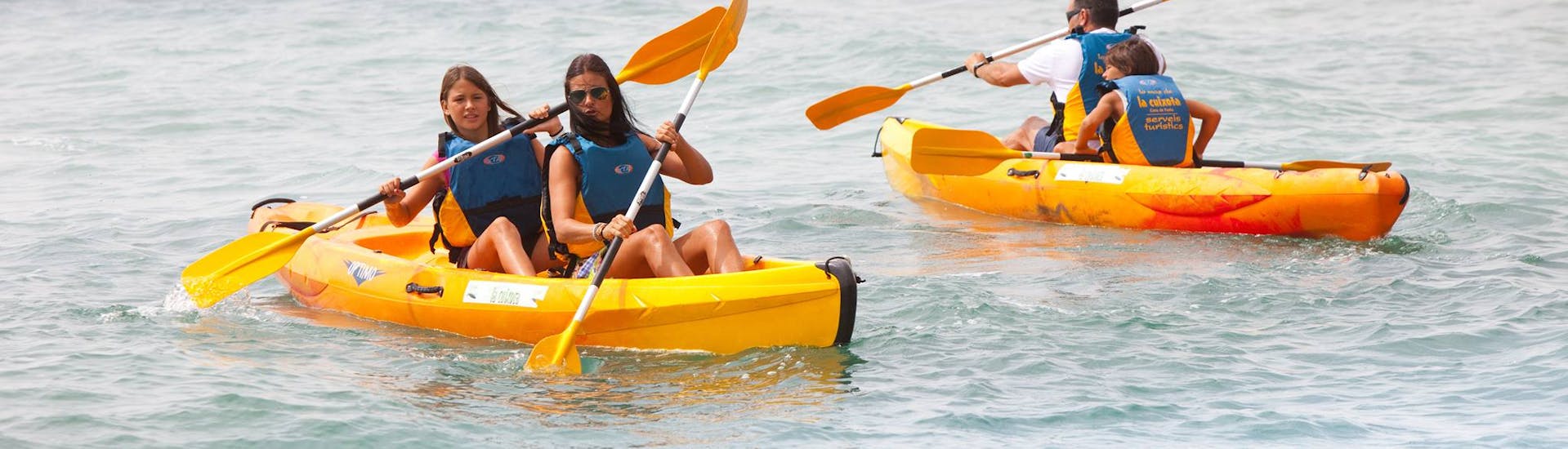 Persone che si divertono durante il noleggio di un kayak da mare a Cova del Llop Marí.