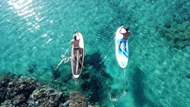 Deux personnes font une location de stand up paddle le long de la Côte des Nacres avec Acqua et Natura. 