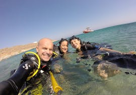 Diving guide with 2 participants in the water during the PADI Advanced Open Water Course at Lia Beach for Certified Divers with GoDive Mykonos.