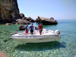 Deux touristes et notre skipper au volant du bateau lors de l'excursion en bateau privé au départ de Palaiokastritsa à Corfou.