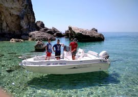 Two tourists and our skipper while driving the boat during the Private Boat Tour from Palaiokastritsa in Corfu.