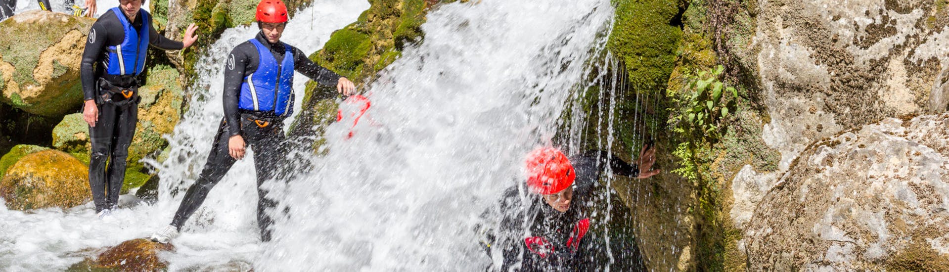 Eine Gruppe von Personen bei einem kleinen Wasserfall während der Privates Extrem-Canyoning auf dem Fluss Cetina mit Iris Adventures Dalmatia.