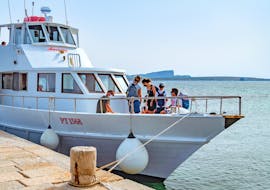 People on board the motorboat Ausonia while it is docked at the pier during the transfer from Stintino to Asinara with Linea del Parco Asinara.