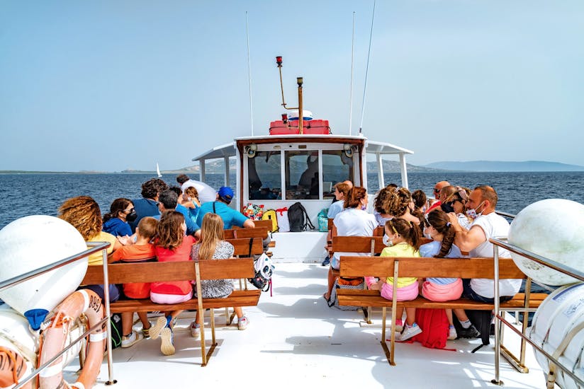 People sitting on the top deck during Transfer in barca da Stintino all'Asinara with Linea del Perco dell'Asinara.